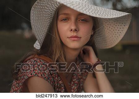 Stock Image - Portrait of serious Caucasian teenage girl wearing sun hat. Fotosearch