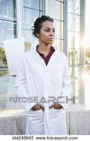 Stock Image - Portrait of serious Mixed Race doctor outdoors at hospital. Fotosearch