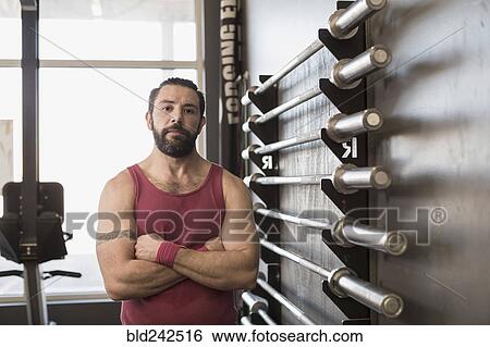 Stock Photograph - Portrait of serious Mixed Race man posing in gymnasium. Fotosearch