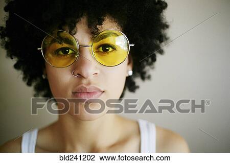Portrait of serious Mixed Race woman wearing yellow sunglasses View Large Photo Image Stock Image - Portrait of serious Mixed Race woman wearing yellow sunglasses. Fotosearch