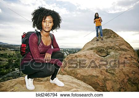 Picture - Portrait of serious women posing on rock formation. Fotosearch