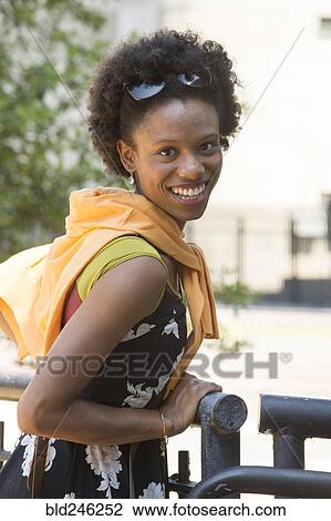 Portrait of smiling African American woman leaning on railing View Large Photo Image Stock Image - Portrait of smiling African American woman leaning on railing. Fotosearch