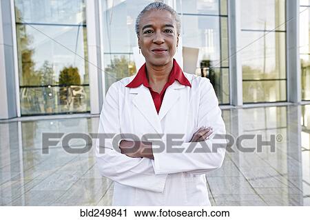 Stock Image - Portrait of smiling African American doctor outdoors at hospital. Fotosearch