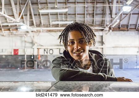Stock Photo - Portrait of smiling androgynous Mixed Race woman. Fotosearch