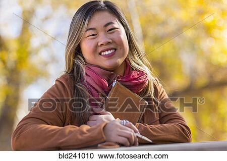 Portrait of smiling Asian woman in autumn View Large Photo Image Stock Image - Portrait of smiling Asian woman in autumn. Fotosearch