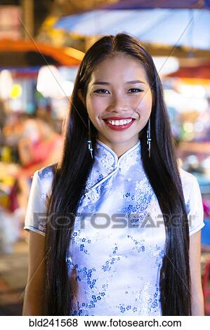 Stock Photo - Portrait of smiling Asian woman wearing traditional clothing. Fotosearch