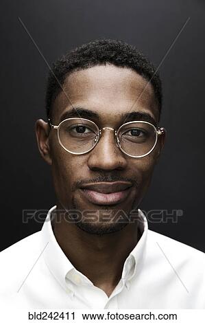Stock Image - Portrait of smiling Black man wearing eyeglasses. Fotosearch