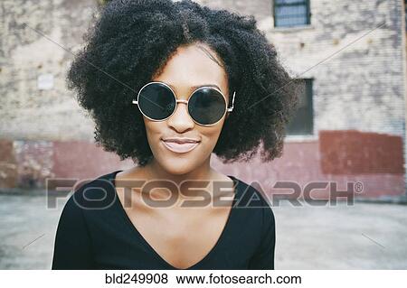Stock Photo - Portrait of smiling Black woman outdoors. Fotosearch