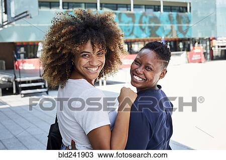 Portrait of smiling Black women hugging in city View Large Photo Image Stock Image - Portrait of smiling Black women hugging in city. Fotosearch