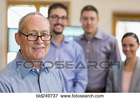 Stock Photo - Portrait of smiling businessman and team. Fotosearch
