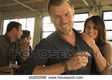Portrait of smiling Caucasian couple drinking beer with friends in brew pub View Large Photo Image Stock Photo - Portrait of smiling Caucasian couple drinking beer with friends in brew pub. Fotosearch