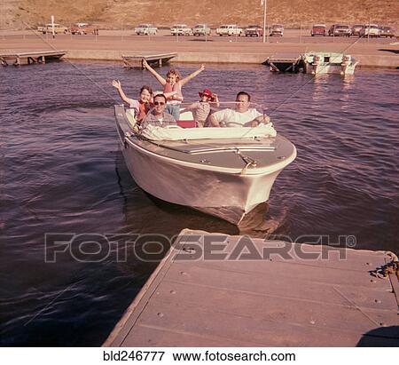 Stock Photo - Portrait of smiling Caucasian family waving on boat near dock. Fotosearch
