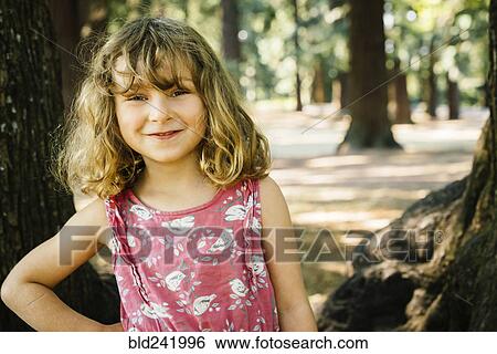 Portrait of smiling Caucasian girl near trees View Large Photo Image Stock Photograph - Portrait of smiling Caucasian girl near trees. Fotosearch