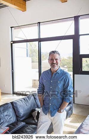 Portrait of smiling Caucasian man in livingroom View Large Photo Image Stock Photograph - Portrait of smiling Caucasian man in livingroom. Fotosearch