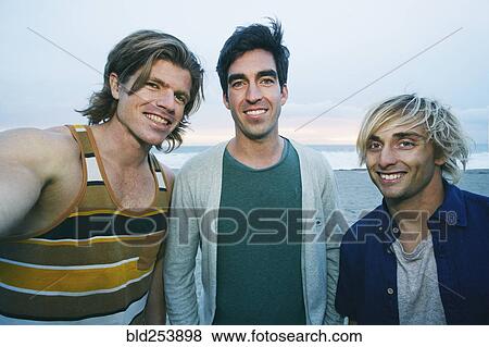 Portrait of smiling Caucasian men at beach View Large Photo Image Stock Photo - Portrait of smiling Caucasian men at beach. Fotosearch