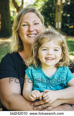 Stock Image - Portrait of smiling Caucasian mother and daughter. Fotosearch