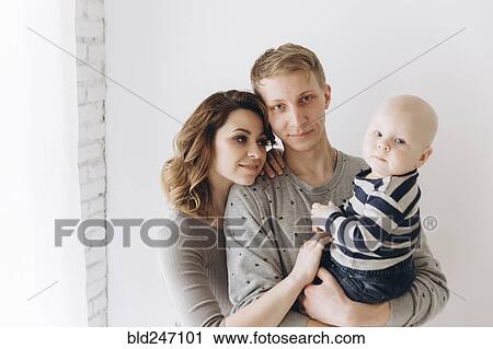 Stock Image - Portrait of smiling Caucasian mother and father with baby son. Fotosearch