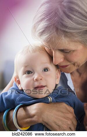 Portrait of smiling Caucasian grandmother hugging baby grandson View Large Photo Image Stock Photograph - Portrait of smiling Caucasian grandmother hugging baby grandson. Fotosearch