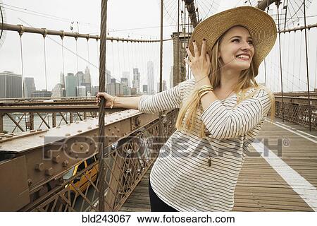 Stock Photo - Portrait of smiling Caucasian woman on bridge. Fotosearch