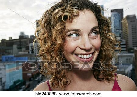 Stock Photo - Portrait of smiling Caucasian woman on urban rooftop. Fotosearch