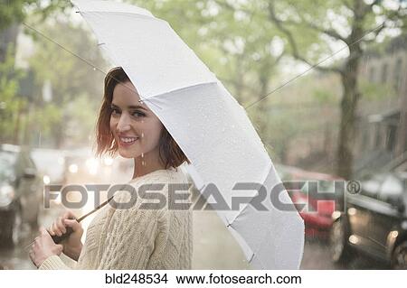 Portrait of smiling Caucasian woman holding umbrella View Large Photo Image Picture - Portrait of smiling Caucasian woman holding umbrella. Fotosearch