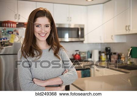 Portrait of smiling Caucasian woman standing in domestic kitchen View Large Photo Image Stock Photo - Portrait of smiling Caucasian woman standing in domestic kitchen. Fotosearch