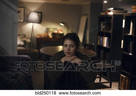 Portrait of smiling Caucasian woman sitting in livingroom at night View Large Photo Image Stock Photo - Portrait of smiling Caucasian woman sitting in livingroom at night. Fotosearch