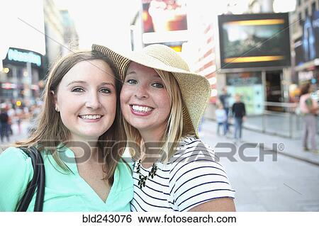 Stock Photograph - Portrait of smiling Caucasian women posing in city. Fotosearch