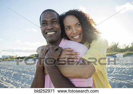 Portrait of smiling couple hugging on beach View Large Photo Image Stock Image - Portrait of smiling couple hugging on beach. Fotosearch