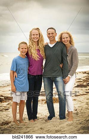 Stock Photograph - Portrait of smiling family at beach. Fotosearch