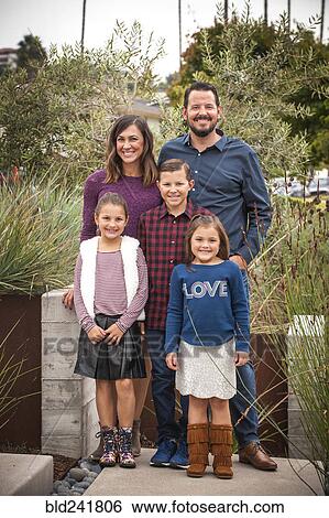Stock Photograph - Portrait of smiling family in garden. Fotosearch