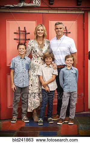 Portrait of smiling family posing near red doors View Large Photo Image Stock Image - Portrait of smiling family posing near red doors. Fotosearch