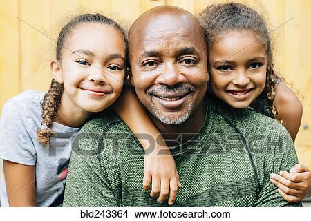 Picture - Portrait of smiling father and daughters. Fotosearch