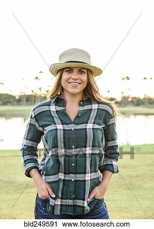 Stock Image - Portrait of smiling Hispanic woman near lake. Fotosearch