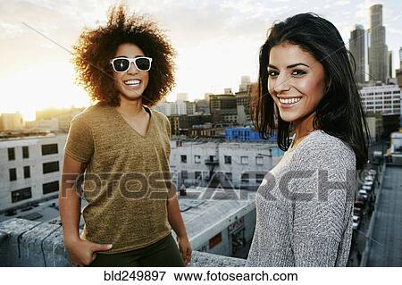 Portrait of smiling Hispanic women on urban rooftop at sunset View Large Photo Image Stock Photo - Portrait of smiling Hispanic women on urban rooftop at sunset. Fotosearch