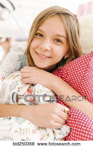 Portrait of smiling Middle Eastern girl holding pillows View Large Photo Image Stock Photo - Portrait of smiling Middle Eastern girl holding pillows. Fotosearch