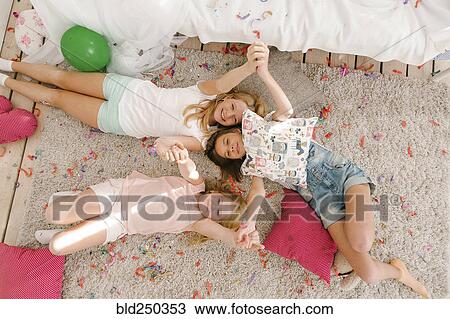 Portrait of smiling Middle Eastern sisters laying on floor holding hands View Large Photo Image Stock Image - Portrait of smiling Middle Eastern sisters laying on floor holding hands. Fotosearch