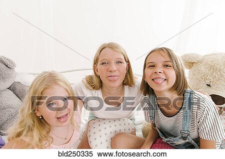 Stock Photography - Portrait of smiling Middle Eastern sisters making a face. Fotosearch