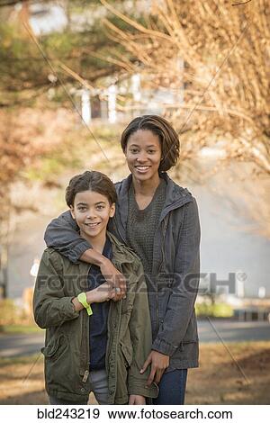 Stock Photo - Portrait of smiling Mixed Race brother and sister outdoors. Fotosearch