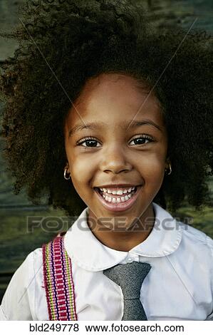 Stock Photo - Portrait of smiling Mixed Race girl near wooden wall. Fotosearch