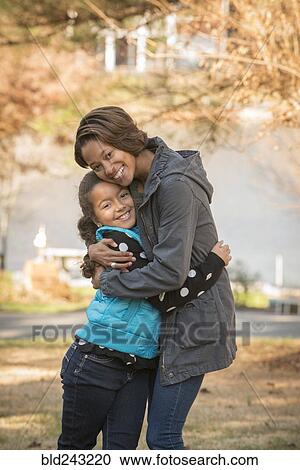 Portrait of smiling Mixed Race sisters hugging outdoors View Large Photo Image Stock Image - Portrait of smiling Mixed Race sisters hugging outdoors. Fotosearch