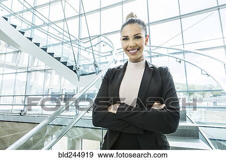 Stock Photo - Portrait of smiling Mixed Race businesswoman standing on staircase. Fotosearch