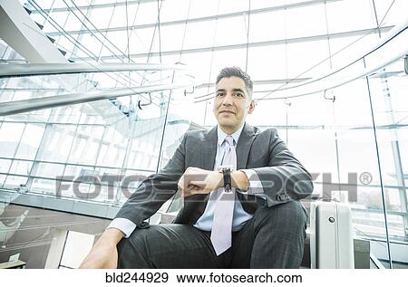Stock Photo - Portrait of smiling Mixed Race businessman sitting on staircase. Fotosearch