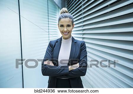 Stock Photograph - Portrait of smiling Mixed Race businesswoman in corridor. Fotosearch