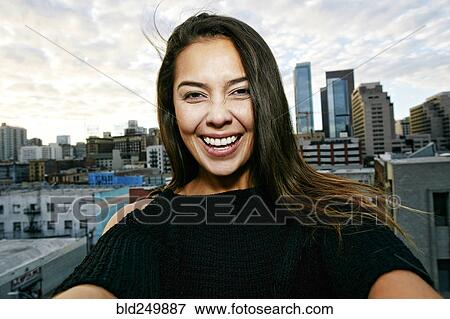 Portrait of smiling Mixed Race woman on urban rooftop View Large Photo Image Stock Photo - Portrait of smiling Mixed Race woman on urban rooftop. Fotosearch