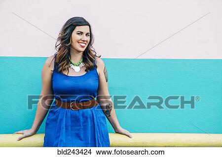Picture - Portrait of smiling Mixed Race woman wearing blue dress. Fotosearch