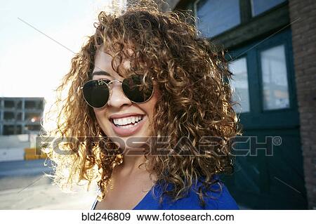 Stock Photo - Portrait of smiling Mixed Race woman posing in city. Fotosearch