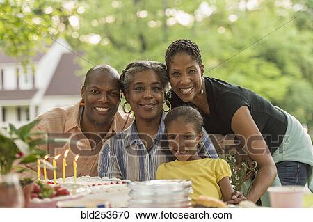 Portrait of smiling multi-generation family celebrating with cake View Large Photo Image Stock Image - Portrait of smiling multi-generation family celebrating with cake. Fotosearch