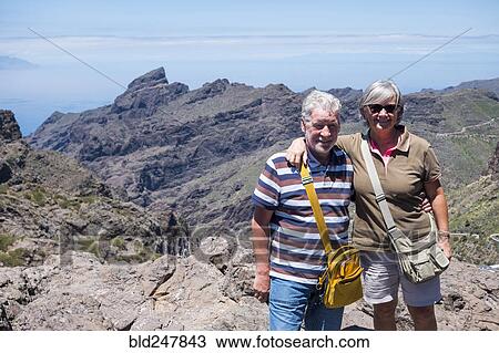 Stock Image - Portrait of smiling older Caucasian couple on mountain. Fotosearch