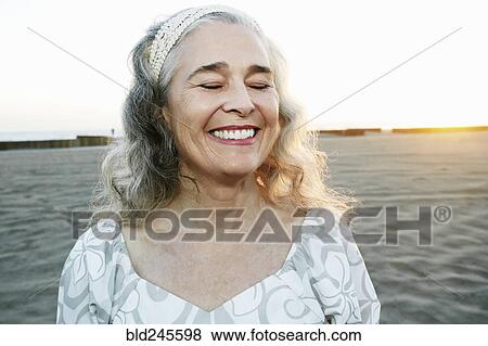 Stock Photo - Portrait of smiling older Caucasian woman at beach. Fotosearch